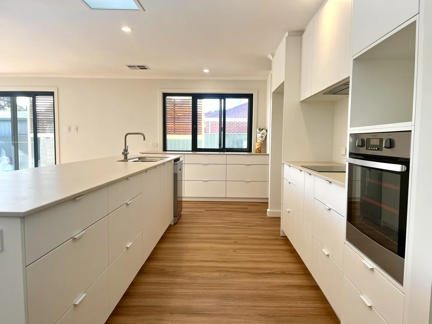 Modern kitchen with island and built-in oven.