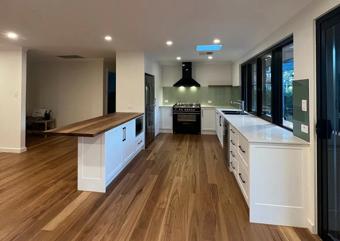 Modern kitchen with wooden floor and white cabinets