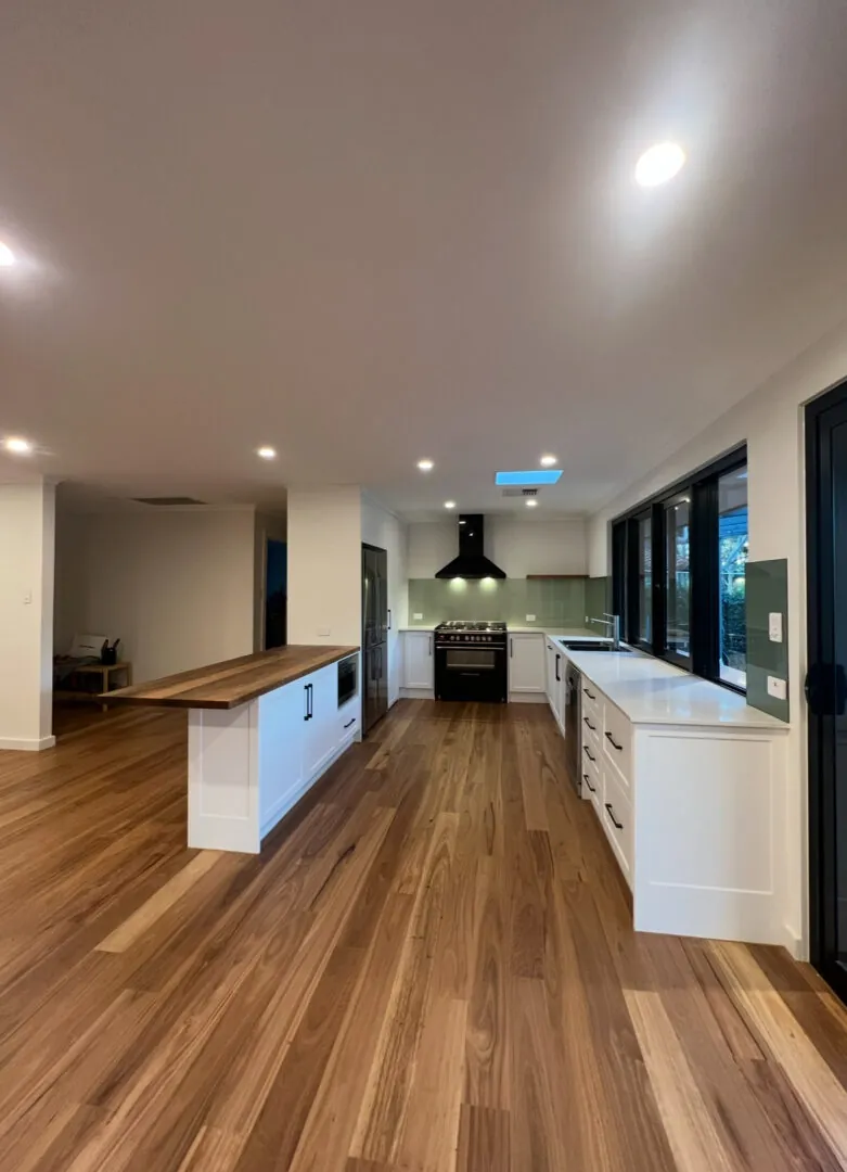 Modern kitchen interior with wooden flooring.